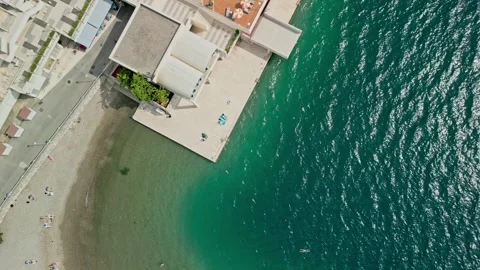 Neum Beach Top Down Dolly Drone Video with People, Cafe, Pool, and Red Boat Stock Footage 330334522