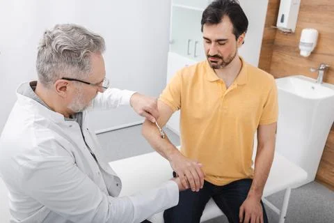 Neurology. Checking man hand reflexes using neurological needle wheel in a .. Фото