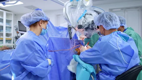 Neurosurgeon uses electric tools looking at microscope.  Stock Footage 307941152