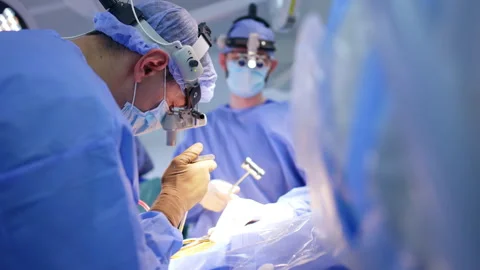 Neurosurgeons use metal tools at operation. Low angle view at the surgeon Stock Footage 318602194
