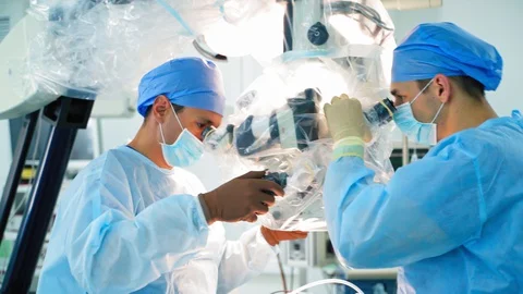 Neurosurgery with high-tech equipment. Two male surgeons working Stock Footage 128239357