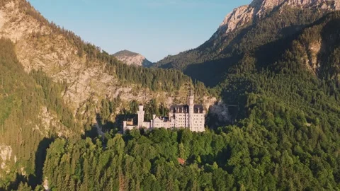 Neuschwanstein castle standing majestically on mountain peak surrounded by Stock Footage 314582907