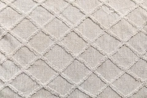 Neutral beige fabric texture with diamond pattern and fringed seams, textile  Stock Photos