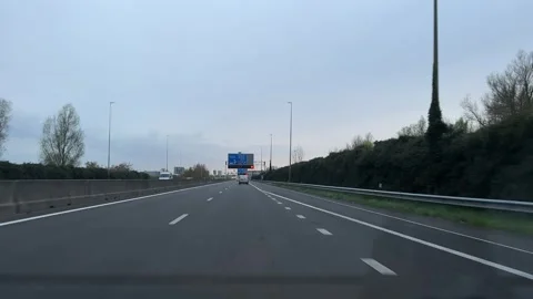 Neutral, calm highway driving on roadside with trees and road signs from Stock-Footage 342756386
