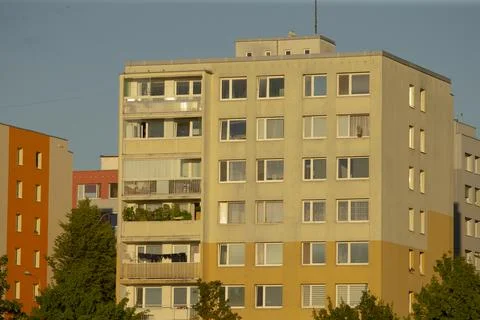 Neutral colored apartment complex with open balconies and clear sky Stock Photos