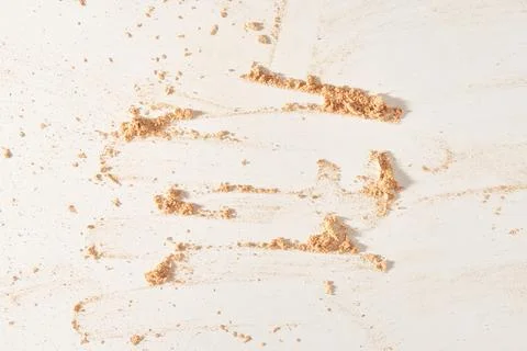 A neutral-colored face powder smeared on the surface, on a light background. Top Stock Photos