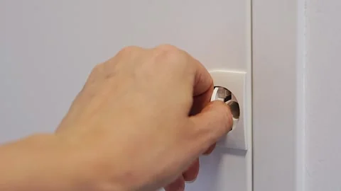 Neutral focused hands inserting plug into electrical outlet in indoor Stock-Footage 346397052
