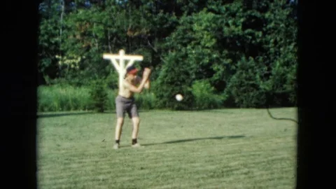 NEVADA USA-1961: Young Boy Plays Catch In Backyard With Wooden Cross Stock Footage 123733712