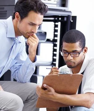 Never fear when the IT guy is near. A young IT specialist ready to fix a server. Stock Photos
