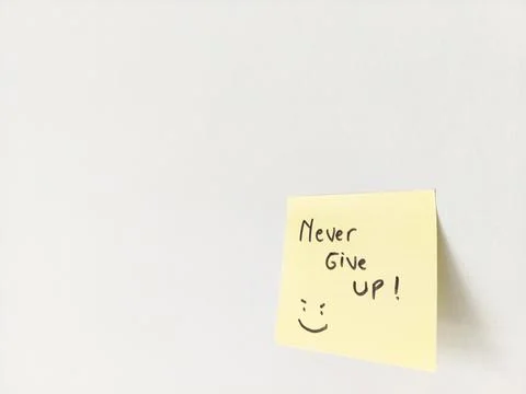 Never Give Up Message and Smiling Doodle on a Sticky Note for Motivation Stock Photos