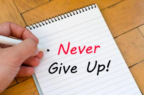 Never give up text concept on notebook Stock Photos