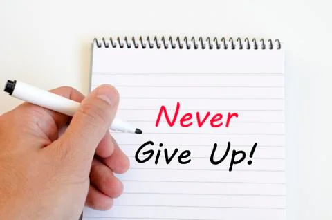 Never give up text concept on notebook Stock Photos