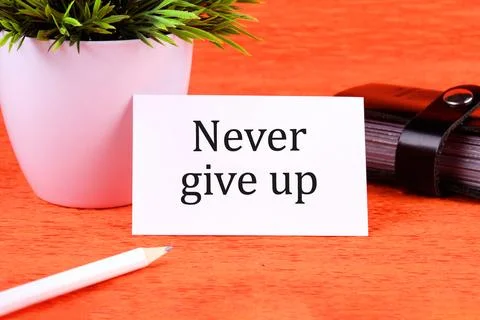 Never give up words it is written on a white business card next to a business Stock Illustration