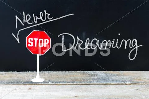 NEVER STOP DREAMING message written on chalkboard Stock Photos