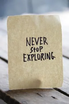 Never stop exploring concept. Motivational quotes inscription on a tag. Stock Photos