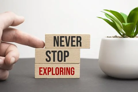 Never Stop Exploring. text on a white sheet of paper on a red notepad on the  Stock Photos