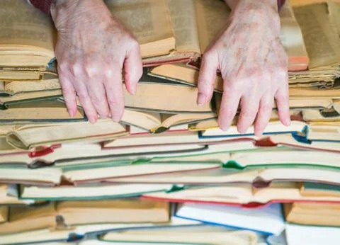 Never too old to learn - Hands of old woman reading book Stock Photos