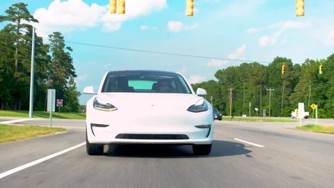 New all electric Tesla Model 3 driving down the road. Stock Footage 97769378