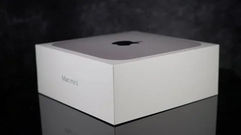 New Apple Mac mini M1 chip computer in a box reflecting on dark glass - Stock Footage 308132922