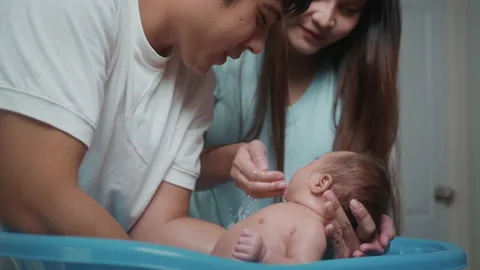 New born having a bath by happy mother and father, family and love concept Stock Footage 202204481
