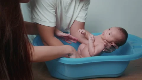 New born having a bath by happy mother and father, family and love concept Stock Footage 202204563