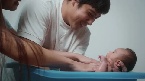 New born having a bath by happy mother and father, family and love concept Видео 202204583