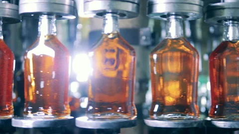 New bottles with cognac are getting relocated by the factory machine Stock Footage 145057699