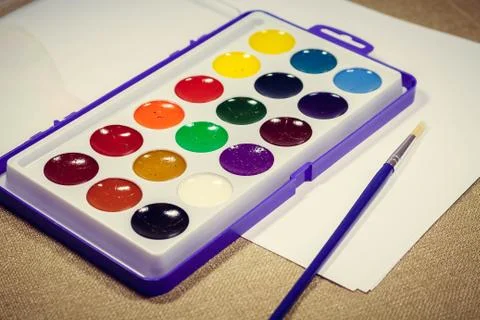 A new box with multi-colored paints and a brush for painting. Diagonally Stock Photos