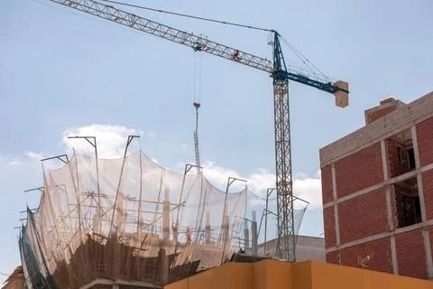 New building construction process. Safety nets and structural beams highlight Stock Photos
