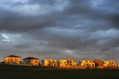 New buildings of the settlement at sunset with clouds Stock Photos