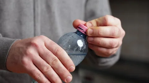 New caps. Hands demonstrate innovative bottle cap design, showcasing unique Stock Footage 320249899