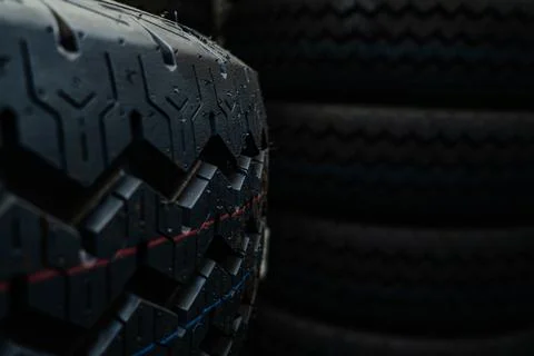 New car tire tread pattern in a dark warehouse. Commercial logistics and au.. Stock Photos