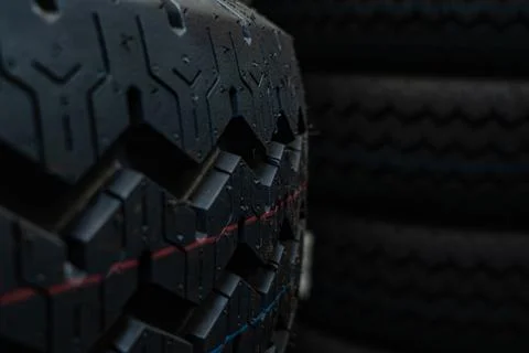 New car tire tread pattern in a dark warehouse. Commercial logistics and au.. Stock Photos