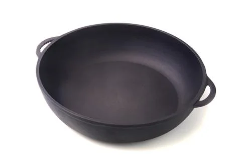 A new, clean and empty cast-iron pan for the grill. Stock Photos