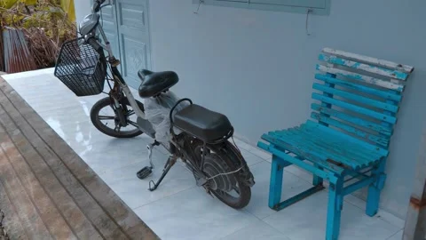A new compact black and white electric bicycle is parked near the home door Видео 333349874