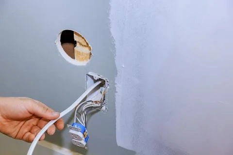 A new current socket is installed by an electrician on the site of a new house Stock Photos