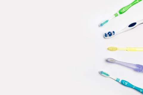 .New different colored toothbrushes on a white background Stock Photos