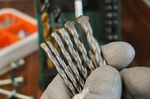 New drills for drilling solid material in the builder's hand Stock Photos