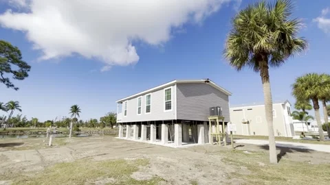 New elevated mobile home resting on high concrete stilt pilings designed for Stock Footage 327512682