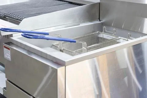 New empty modern professional deep fryer basket for  kitchen restaurant Stock Photos