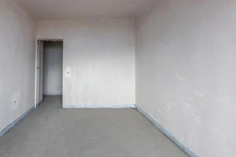 New empty room under construction. Plaster walls. New home. Concrete walls. I Stock Photos