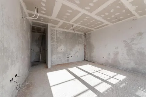New empty room under construction. Plaster walls. New home. Concrete walls. I Stock Photos