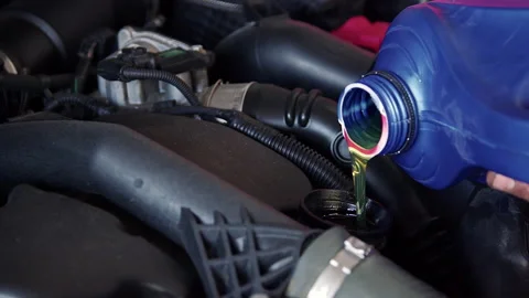 New Engine Oil is Pouring into the Car Engine At Workshop 1 Stock Footage 171897342