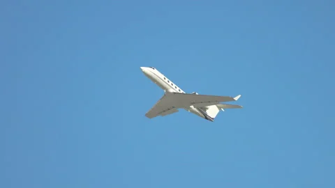 New Generic Unmarked Private Jet Flying Into a Clear Blue Sky Stock Footage 247136596