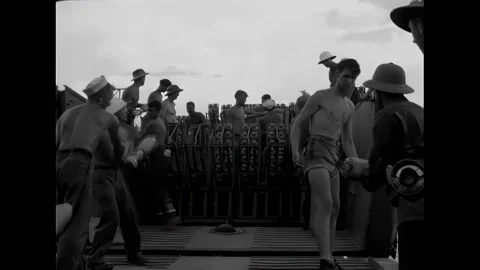 NEW GUINEA - 1944 - US troops load 4.5" rockets on a mechanized landing craft on Video stock 312793338