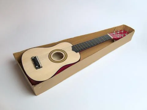 New half size children's learning guitar in a cardboard box Stock Photos