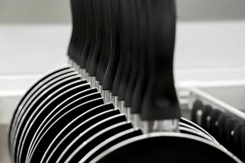 New hang in a row pans in the store. cooking utensils Stock Photos