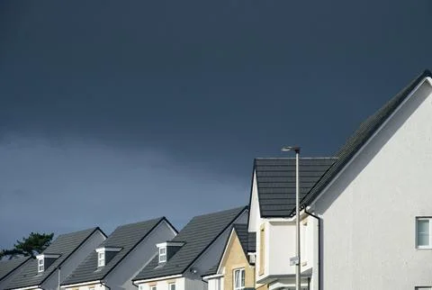 New housing development under dark storm clouds Stock Photos