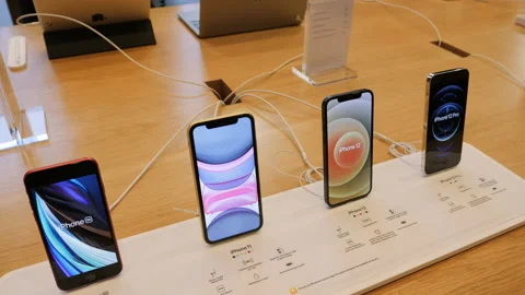 New iPhone 12 and iPhone 12 Pro on display during launch day next to SE and 11 Stock Footage 141773506