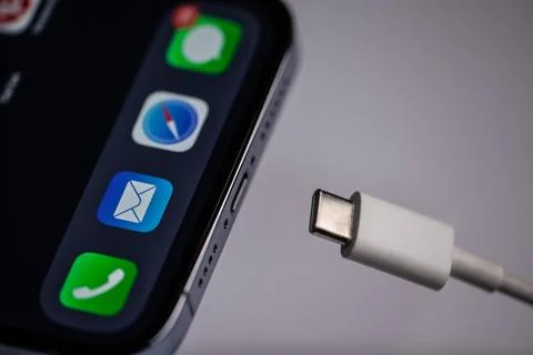 The new iphone with white type-c charger on a gray background. Moldova,Hincesti Stock Photos